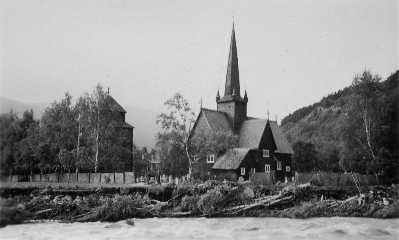Historisk sort hvitt bilde av flommen i 1938, elven i forgrunnen som grever seg inn mot kirkebakken.