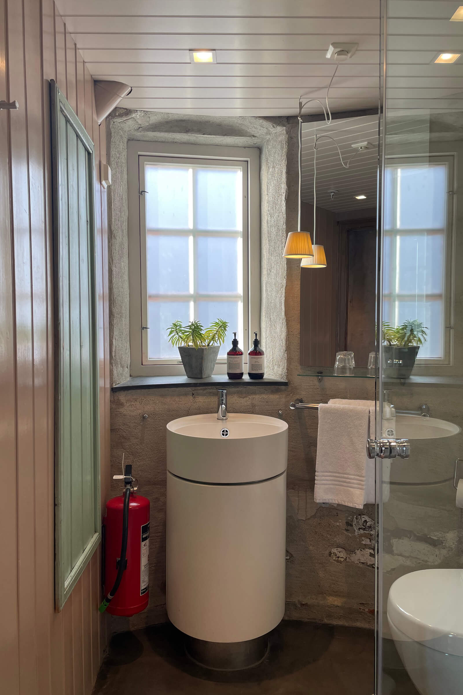 Fotografi av baderommet, På bilde vises vask, dusj og toalett. Badrommet har et lite vindu som er foliert slik at det beskytter mot innsyn.